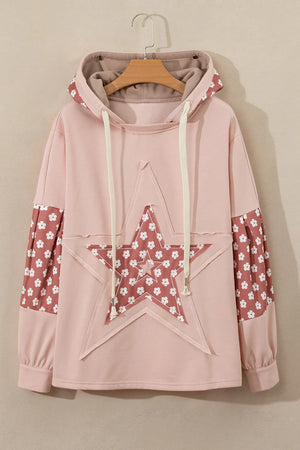 Dusty pink hoodie with floral star patchwork on front and sleeves, drawstring hood.