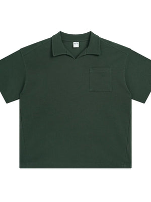 Dark green boxy knit polo shirt with a patch pocket and spread collar.