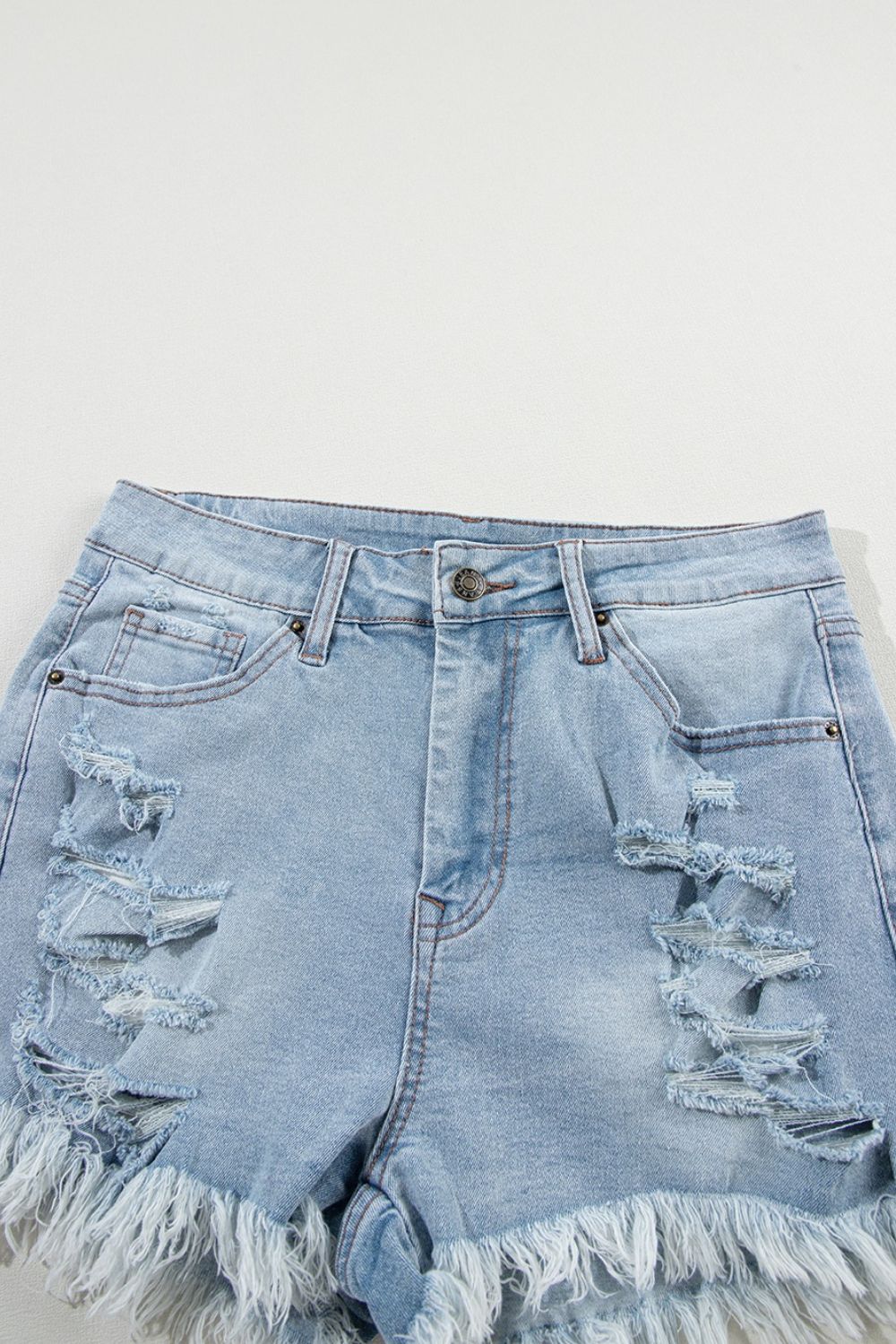 Light blue distressed denim cutoff shorts with frayed hem and ripped details.