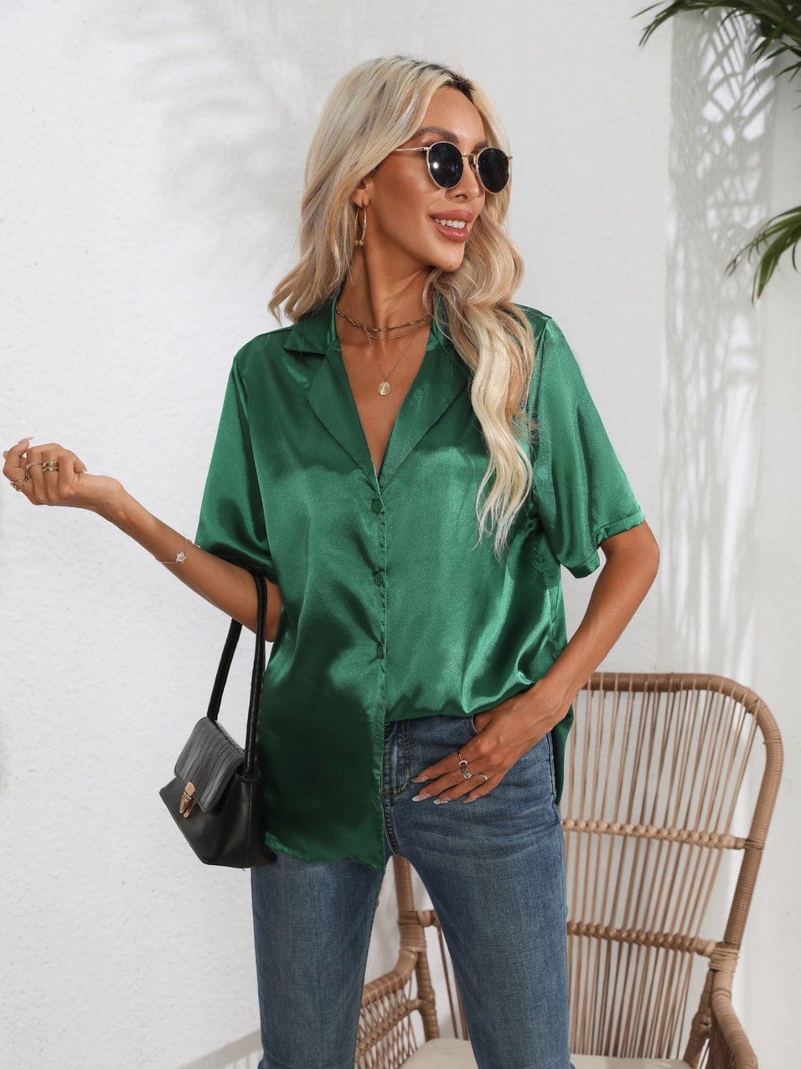 Dark green satin collared shirt with short sleeves and button front, styled with jeans.