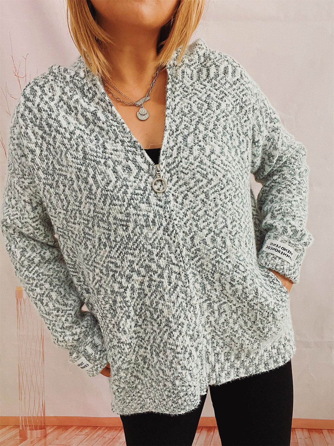 Speckled knit relaxed zip-up hoodie in a light grey and white blend, featuring a ring zipper and pockets.