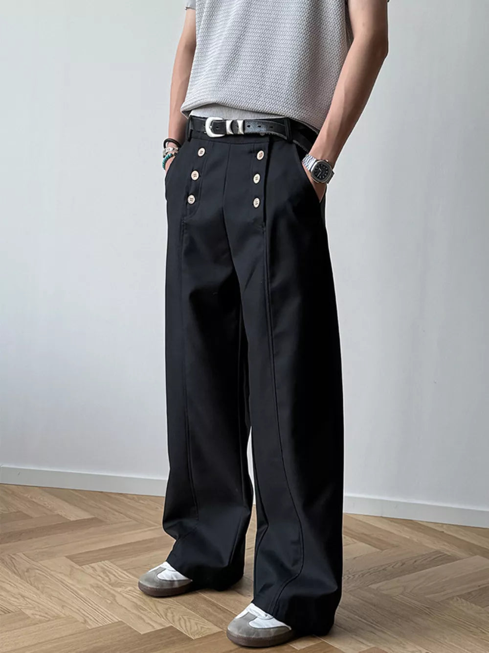 Black high-waisted wide leg pants with button detail and a relaxed fit.