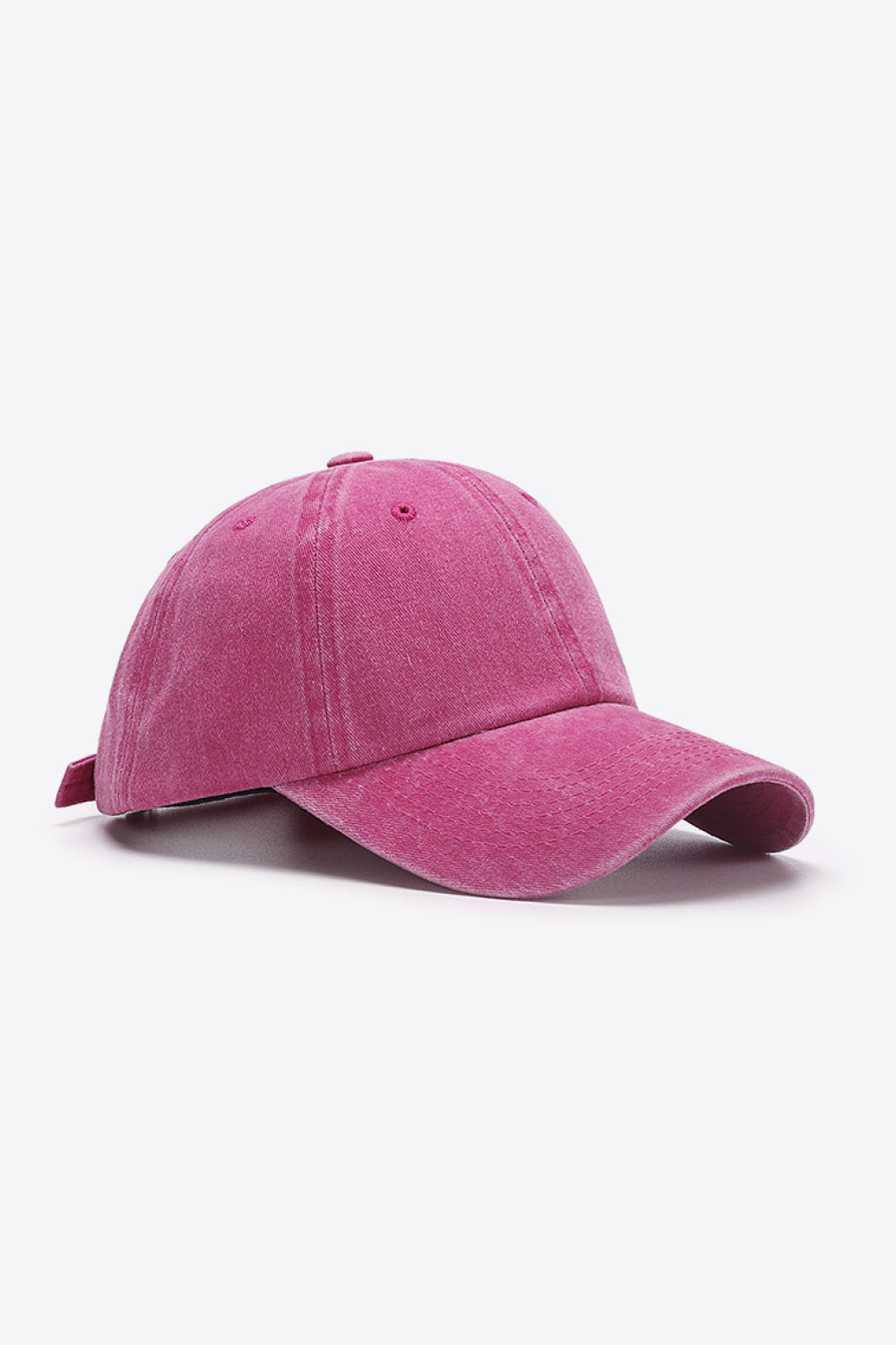 Washed cotton baseball cap in magenta with adjustable strap.