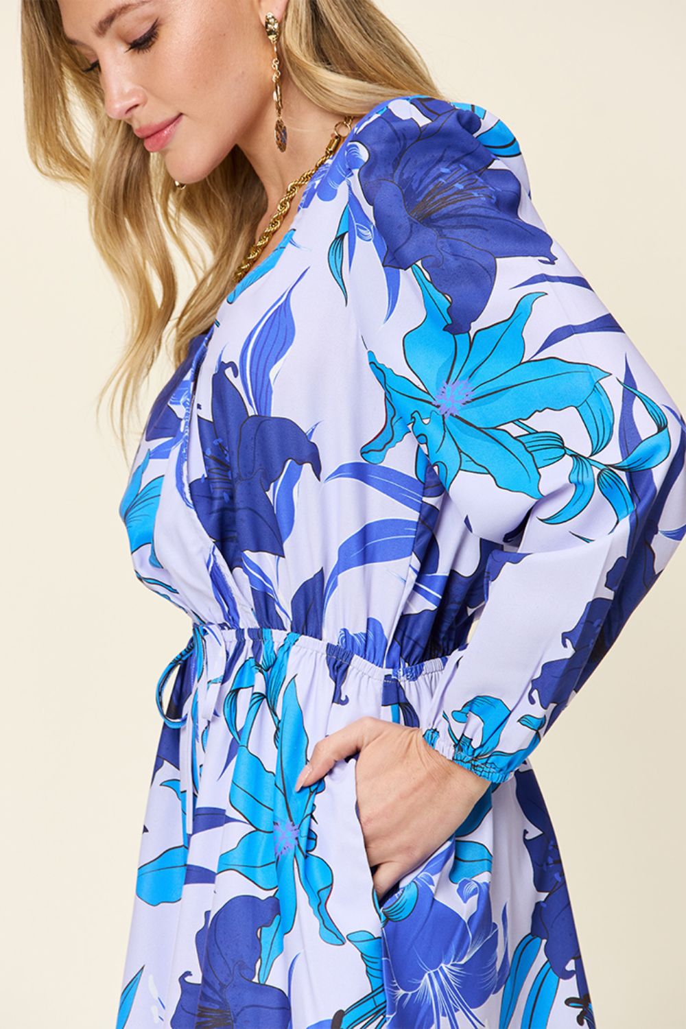 Blue floral wrap romper with long sleeves and cinched waist