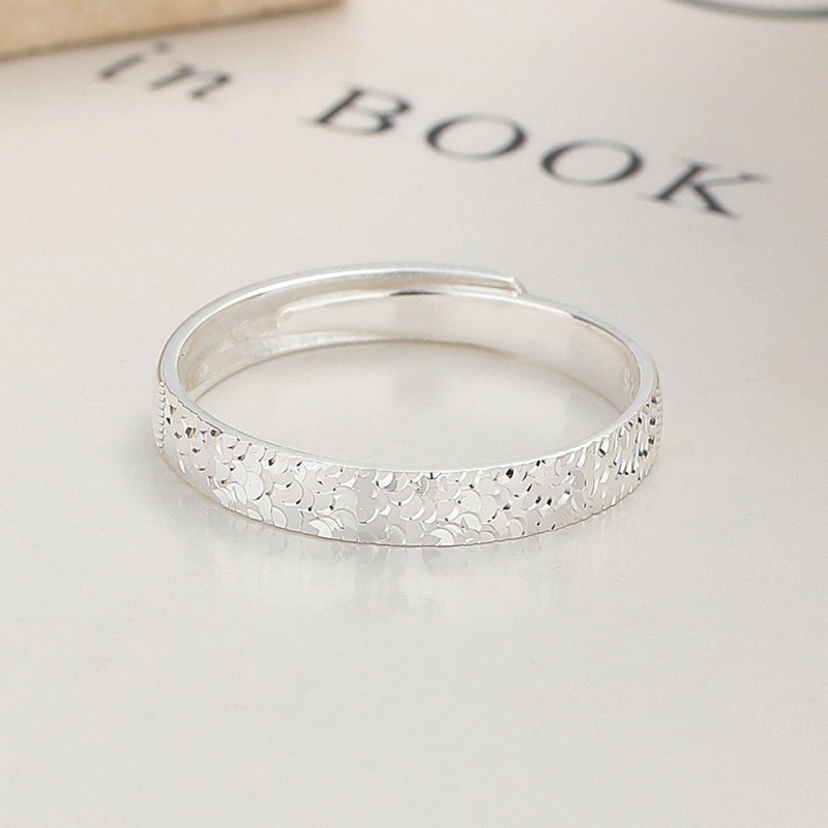 Textured sterling silver adjustable ring with a subtle hammered pattern.