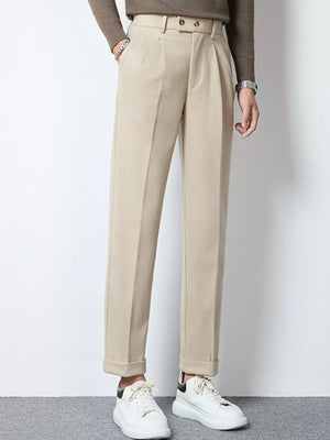 Men's khaki pleated dress pants with cuffed hems and a belted waist.