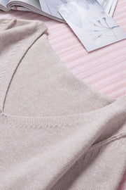 Off-the-shoulder knit sweater in eggshell with fringe trim detail.