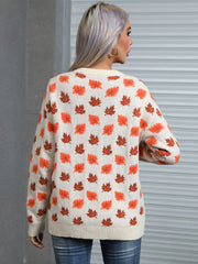 Cream knit crewneck sweater with allover orange and brown autumn leaf pattern.