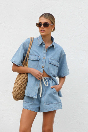 Light wash denim shirt and drawstring shorts set with button front and pocket details.