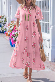 Pink floral cotton midi dress with flutter sleeves and tiered skirt.