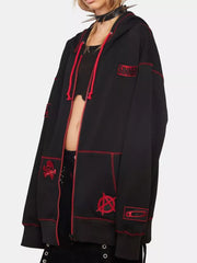 Black zip-up hoodie with red contrast stitching and graphic patches like skull and anarchy symbol.
