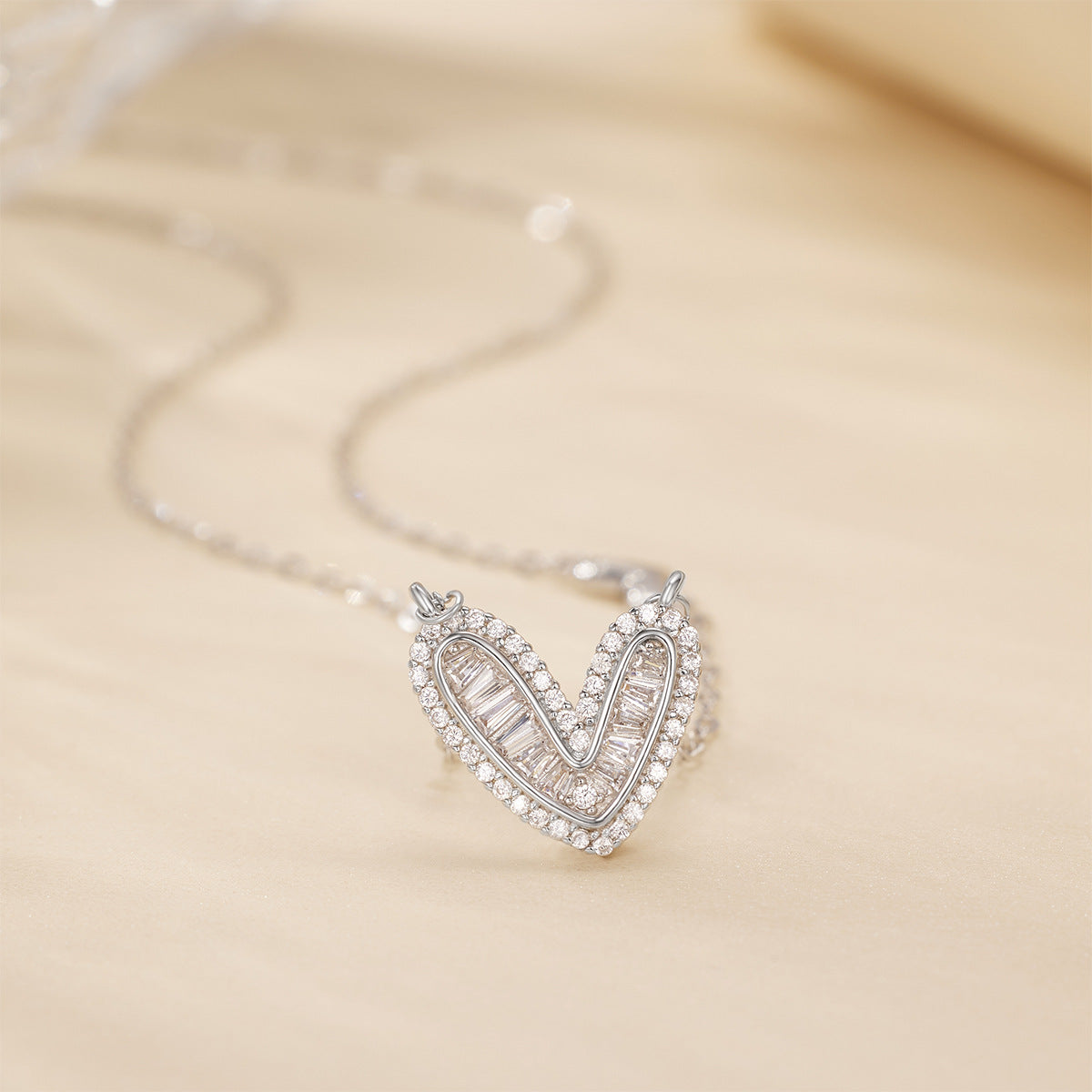 Sterling silver heart pendant necklace with baguette and round crystals on a delicate chain.