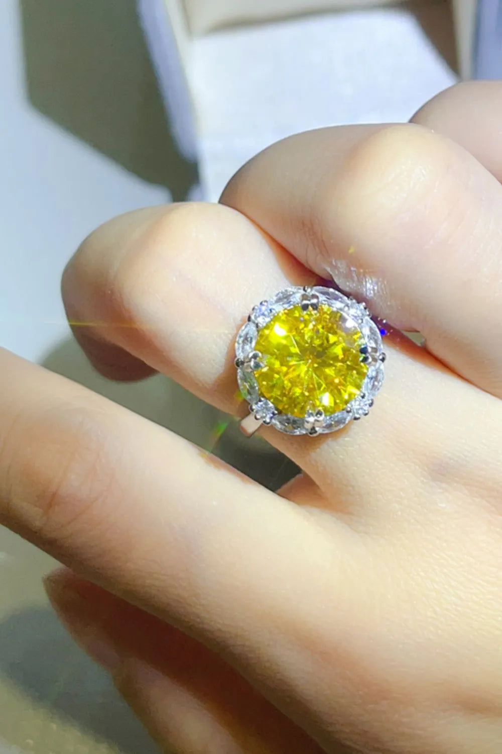 Radiant Halo Yellow Gemstone Ring with clear accent stones on a silver band.