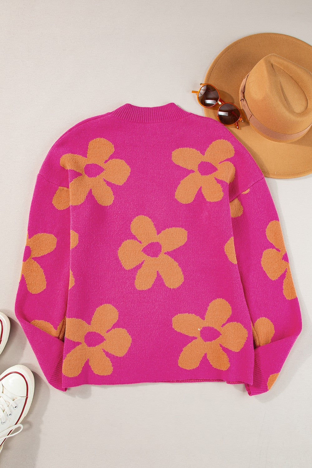 Cerise knit oversized sweater with an allover orange retro floral print.
