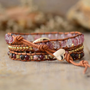 Bohemian wrap bracelet with red gemstones, gold beads, and heart charm on leather cord.