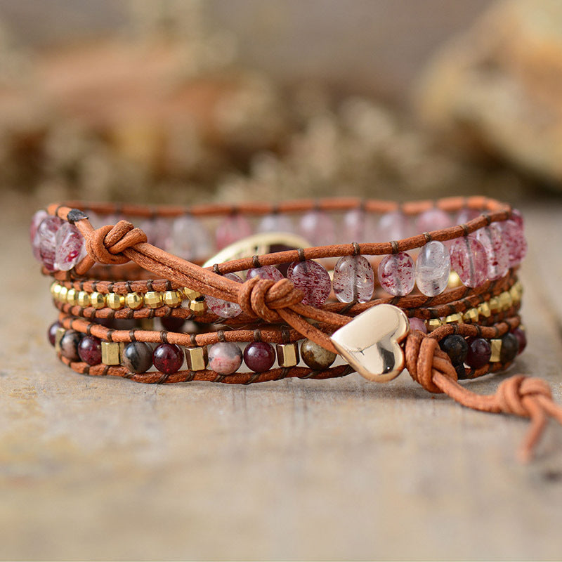 Bohemian wrap bracelet with red gemstones, gold beads, and heart charm on leather cord.