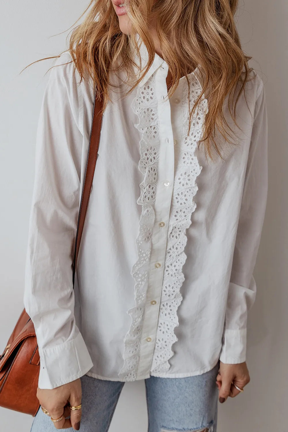 White cotton shirt with eyelet ruffle front detail and button closure.