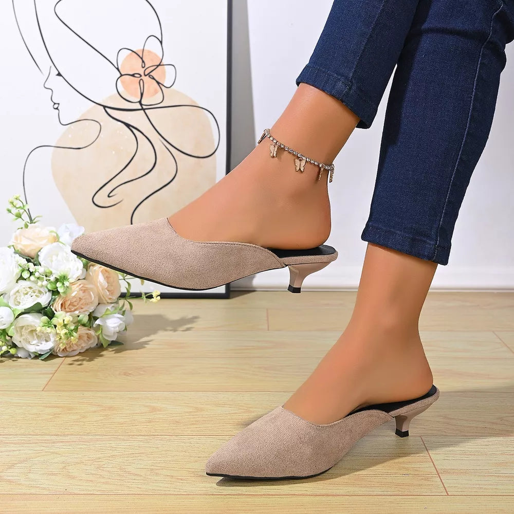 Apricot pointed-toe kitten heel mules with a low heel and open back.