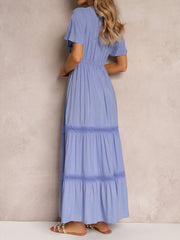 Blue lace-embellished tiered maxi dress with short sleeves and a cinched waist.
