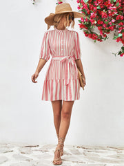 Blush pink vertical stripe shirred waist dress with puff sleeves and tie belt.