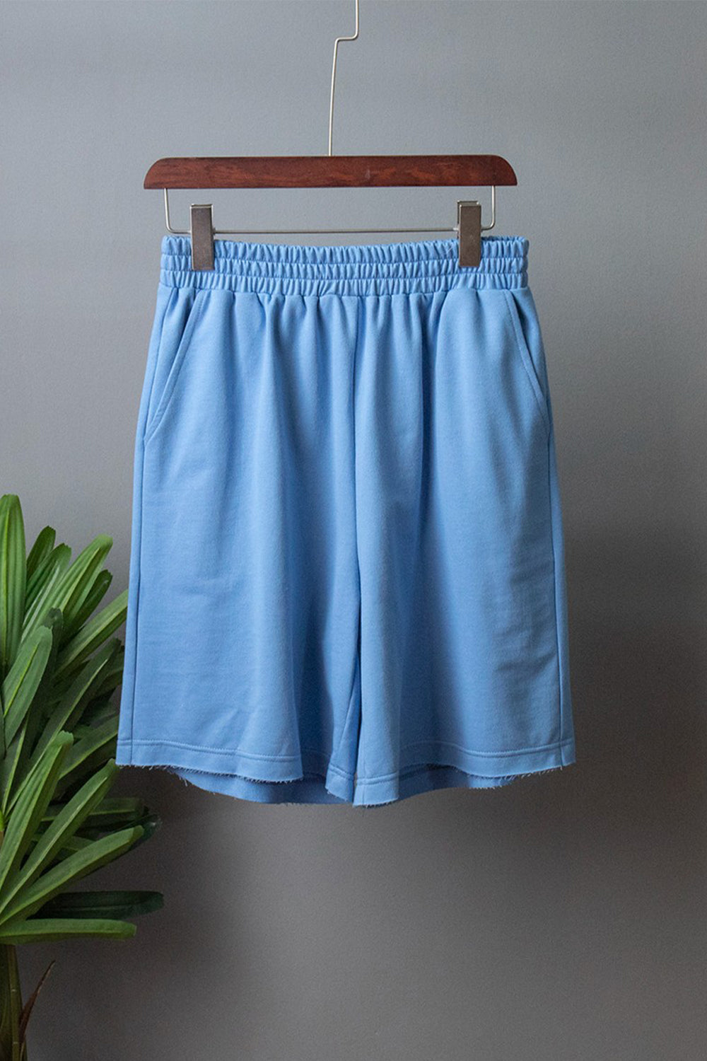 Pastel blue relaxed fit shorts with elastic waist and raw hem detail