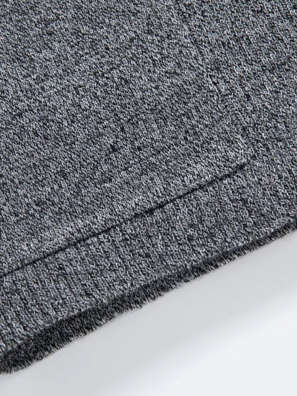 Men's gray marled knit open-front cardigan detail, showing ribbed hem.