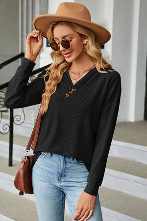 Black textured henley v-neck top with button detail and long sleeves
