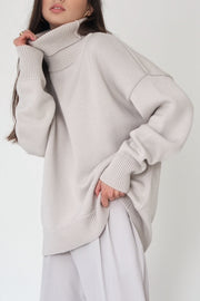 Relaxed roll-neck sweater in light gray knit with a boxy cut and ribbed cuffs and hem.