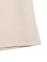Embellished linen two-piece set in cream, showing textured fabric detail.