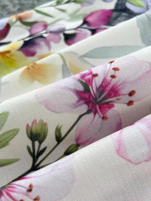 Vibrant floral midi dress fabric with pink blossoms and green leaves.