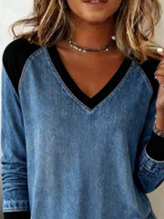 Patchwork denim blouse with black V-neck, long sleeves, and banded cuffs.