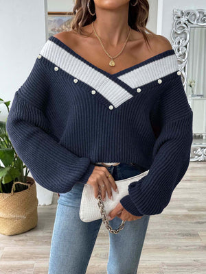 Dark blue ribbed knit sweater with V-neck and pearl button trim.