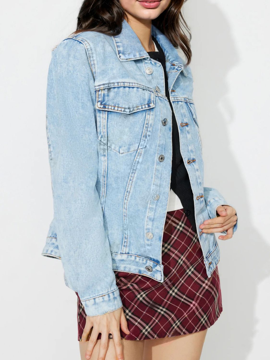 Light wash denim jacket with classic buttoned front and chest pockets.
