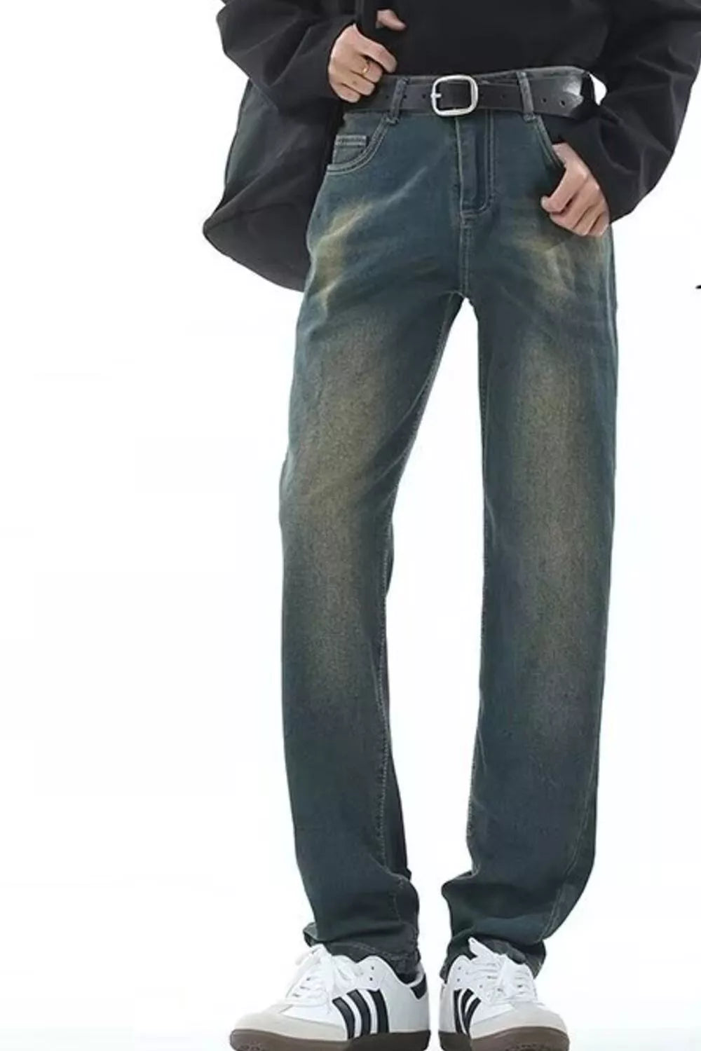 Men's straight-leg jeans in vintage wash denim with a black belt and white sneakers.