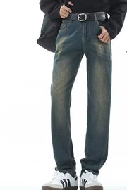 Men's straight-leg jeans in vintage wash denim with a black belt and white sneakers.
