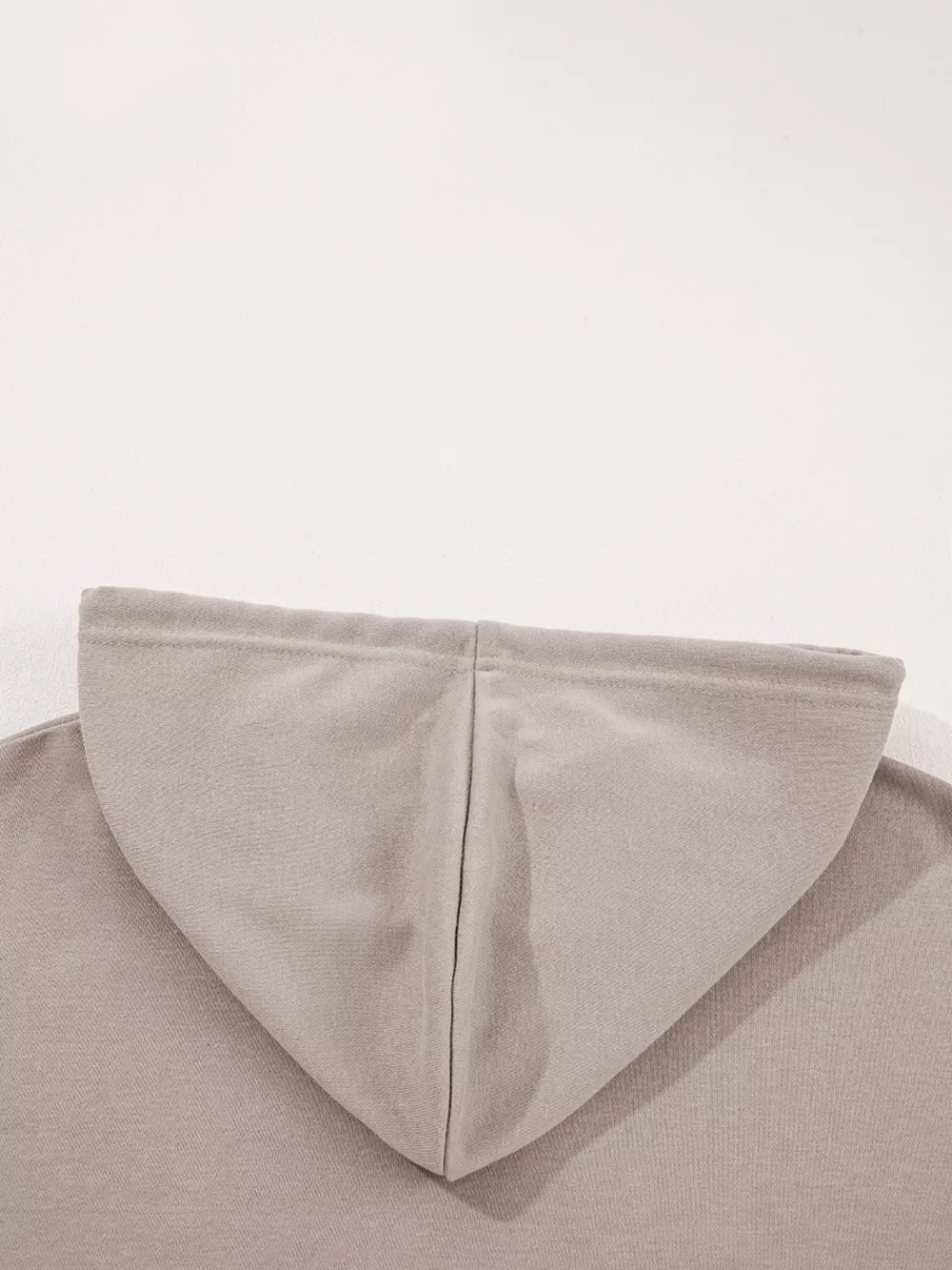 Relaxed fit cotton hoodie in a light taupe multi-tonal shade, showing the hood seam detail.