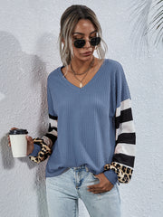Sky blue waffle knit top with colorblock striped and leopard print sleeves.