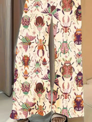 Whimsical print wide-leg maternity trousers in pastel yellow with colorful beetle and butterfly pattern.