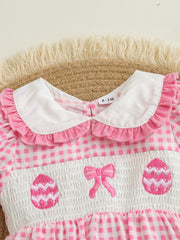Pink gingham one-piece with smocked chest, embroidered Easter eggs and bow, white ruffled collar.