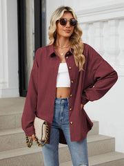 Burgundy corduroy oversized shirt jacket with button front and collar, styled with jeans.