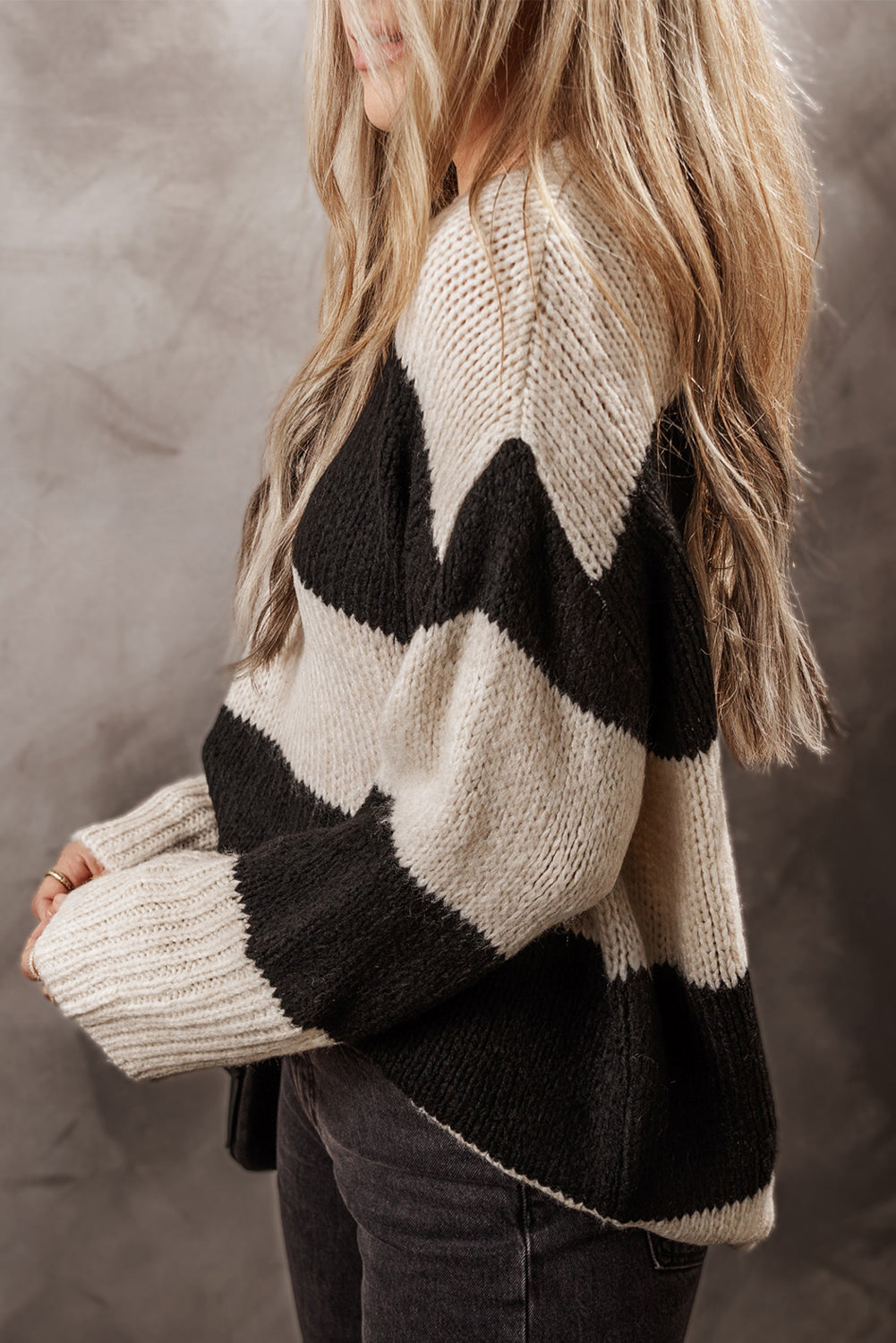 Relaxed knit sweater in black and cream with bold chevron stripes and an acrylic blend.