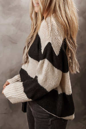 Relaxed knit sweater in black and cream with bold chevron stripes and an acrylic blend.