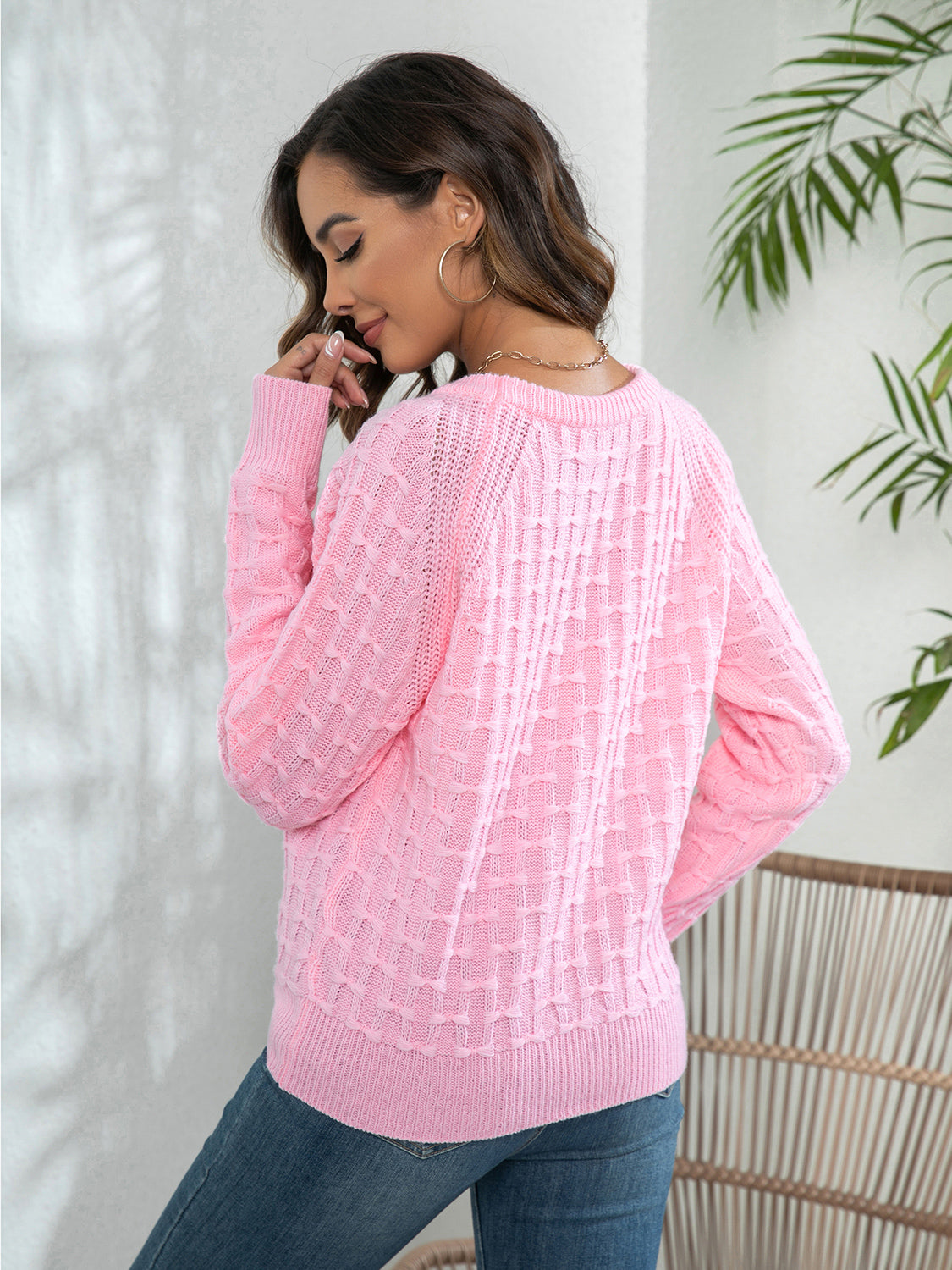 Pink crewneck knit sweater with textured pattern and button detail