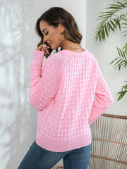 Pink crewneck knit sweater with textured pattern and button detail