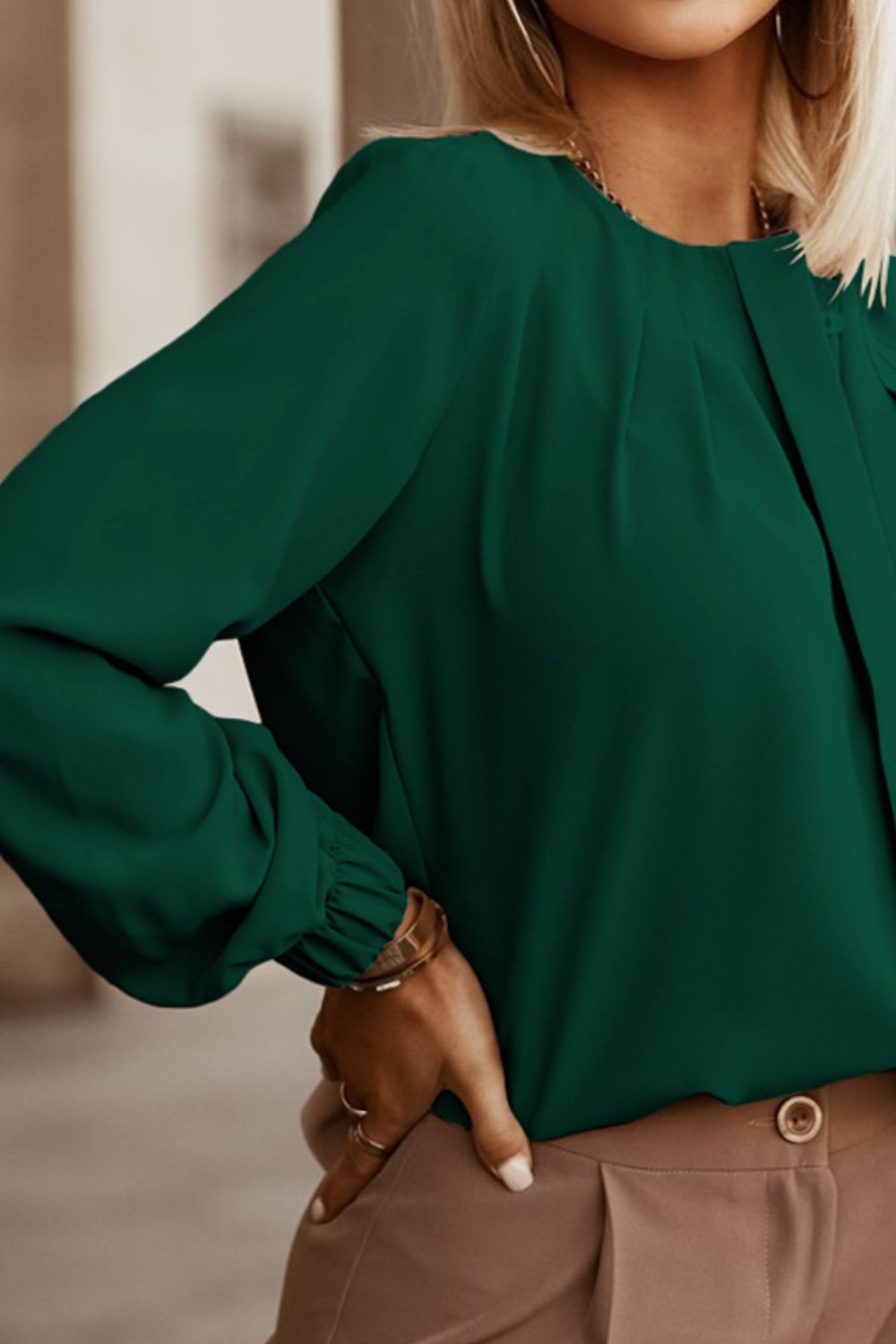 Green long sleeve blouse with pleated yoke and button detail.