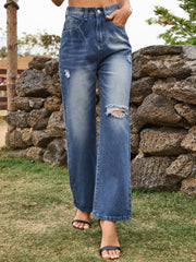 Distressed blue denim flare jeans with ripped details and a buttoned waist.