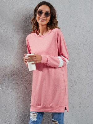 Varsity stripe raglan sweatshirt dress in pink with white sleeve stripes, crew neck, and side slits.