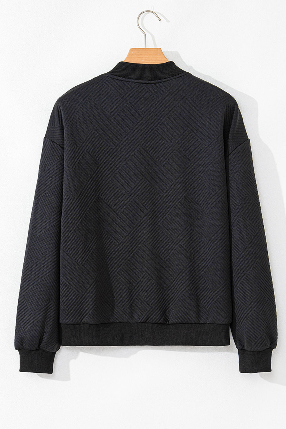 Black bomber jacket with textured diamond quilting and ribbed collar, cuffs, and hem.