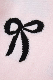 Blush pink knit sweater with a black bow motif detail.