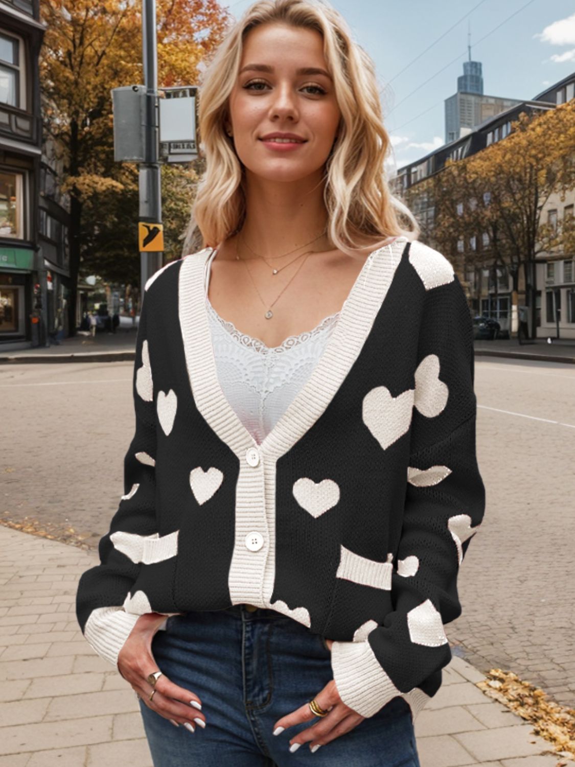 Black acrylic cardigan with white intarsia hearts and cream trim, button front, V-neck